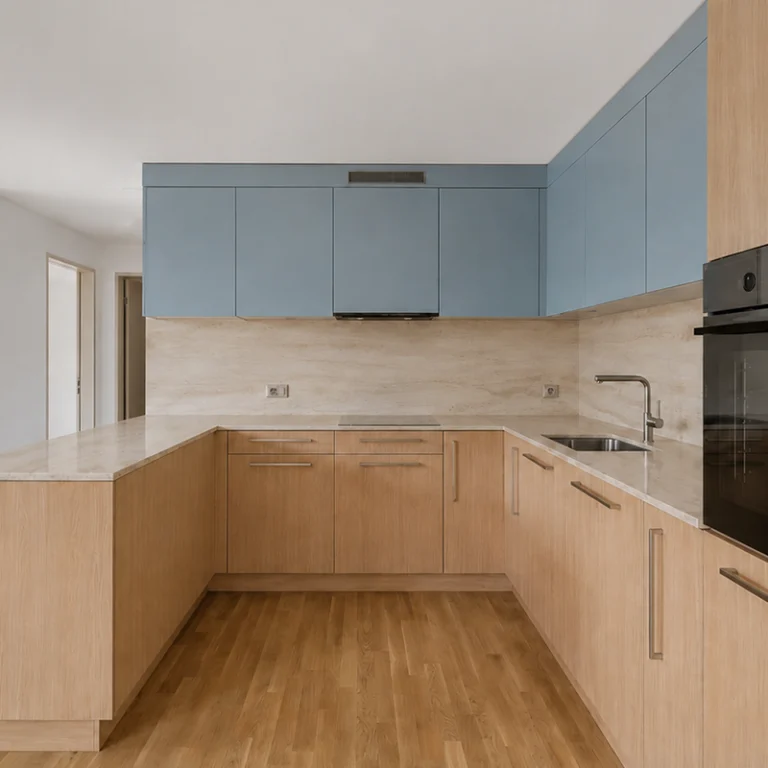 Cuisine en U, meubles bas en bois clair et meubles hauts bleus, plan et crédence en travertin beige, four noir en colonne, parquet clair