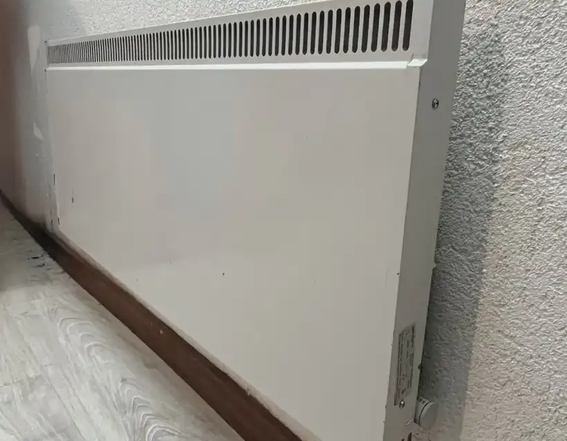 Convecteur électrique mural blanc dans un logement romand