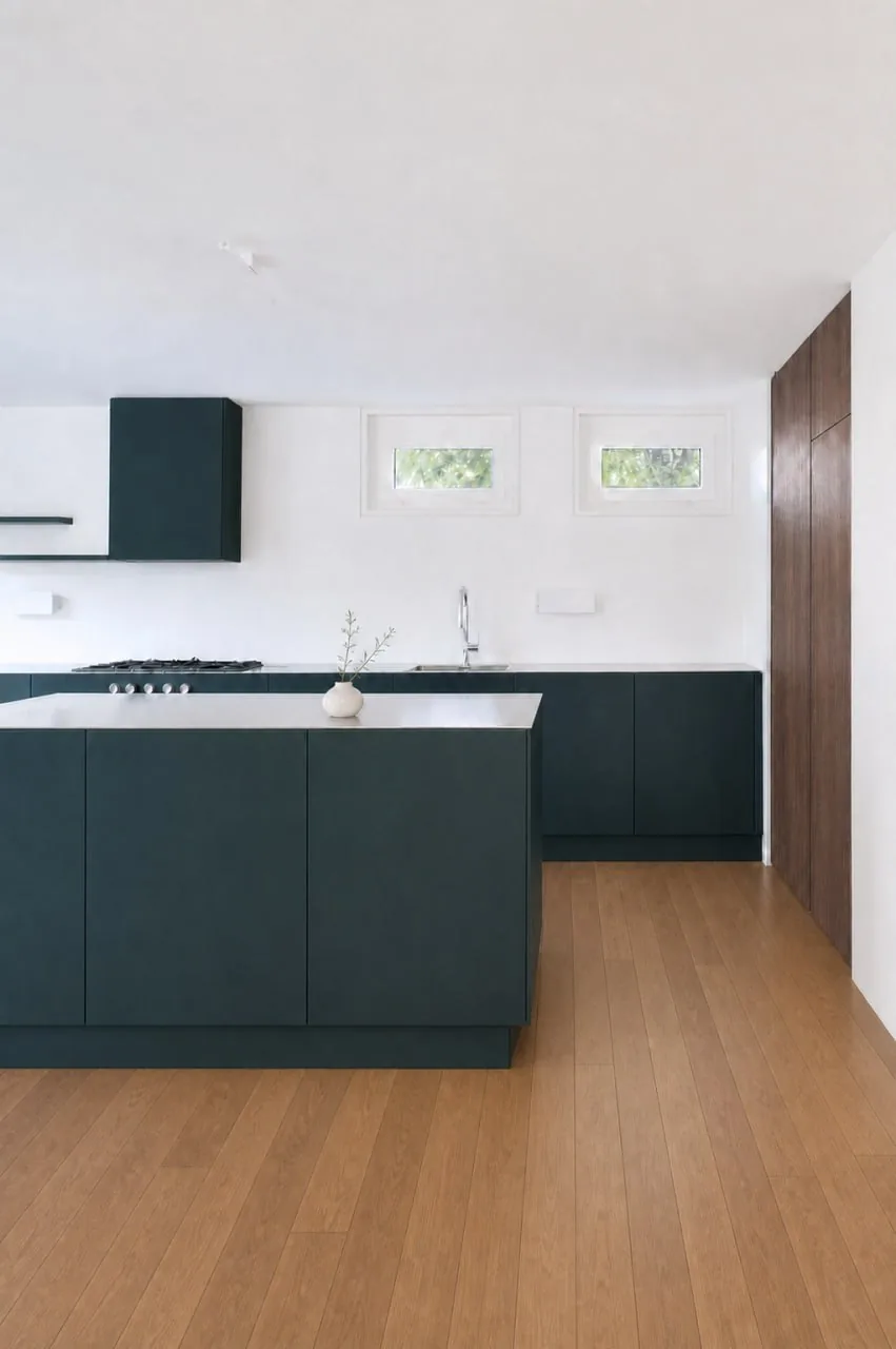 Îlot de cuisine vert foncé sur parquet, hotte suspendue assortie