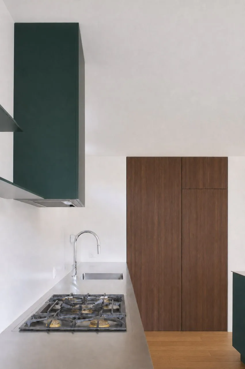 Cuisine à hotte et façades vert foncé, colonne en bois brun foncé et plaque à gaz