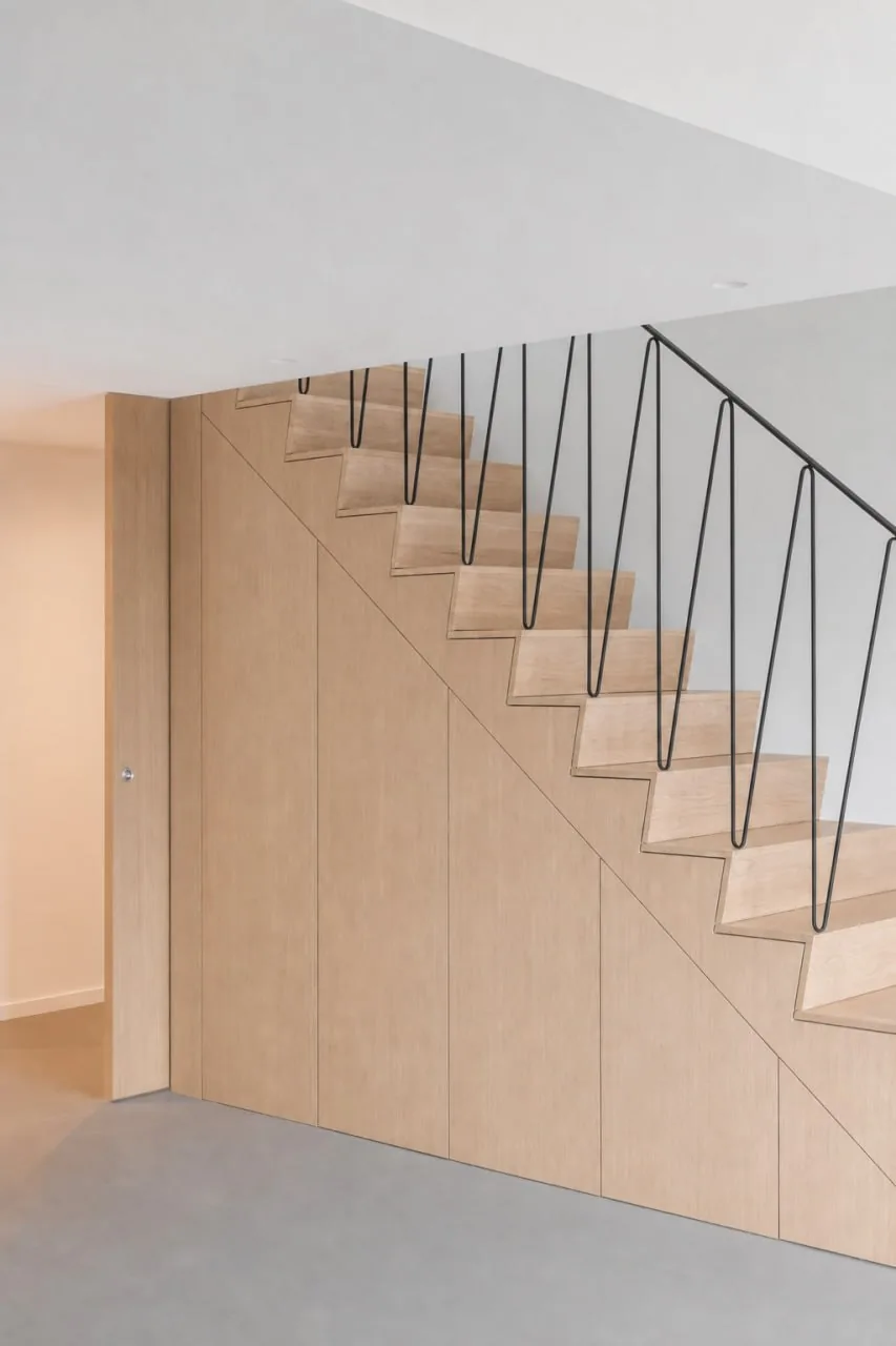 Escalier bois clair avec rangement intégré et garde-corps métallique fin