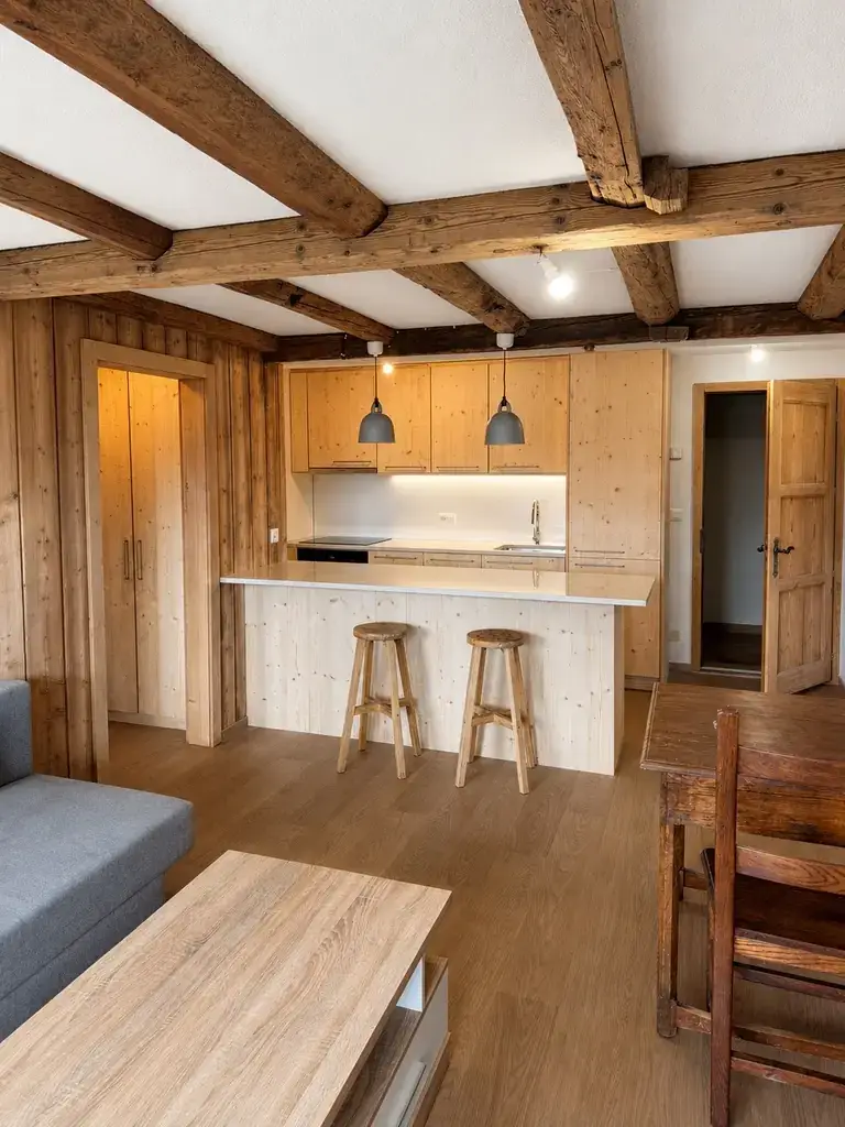 Séjour ouvert sur la cuisine, îlot et mélèze, appartement rénové à Verbier