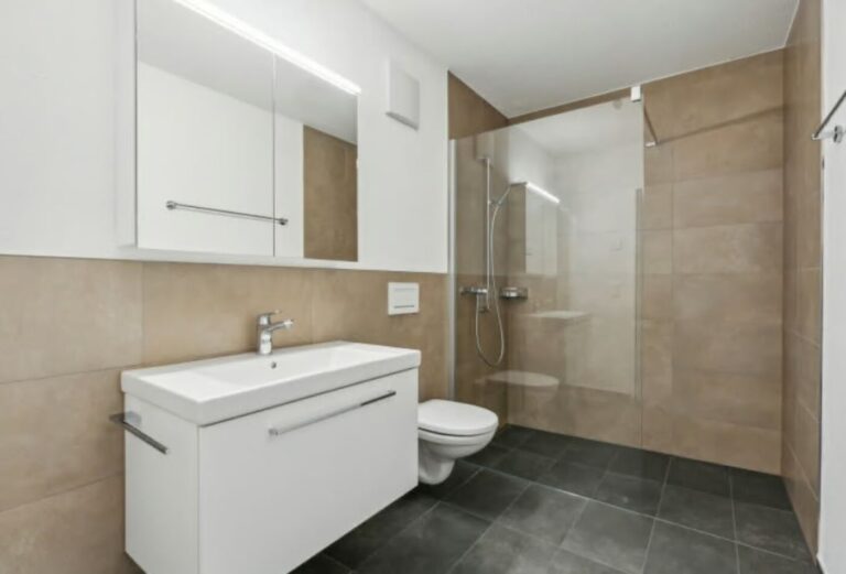 Salle de bain rénovée en beige avec douche de plain-pied et sol anthracite